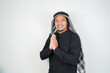 © Aria Armoko - Happy smiling Asian Muslim man in Arabic turban sorban standing with Eid greeting gesture and welcoming Ramadan isolated