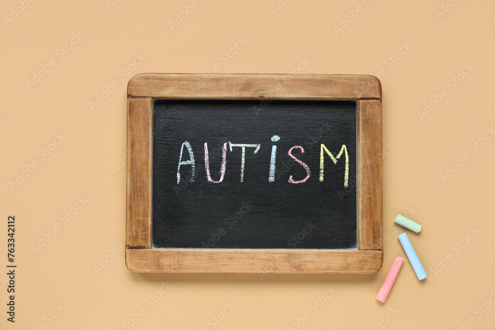 Blackboard with word AUTISM on beige background. Autism disorder concept