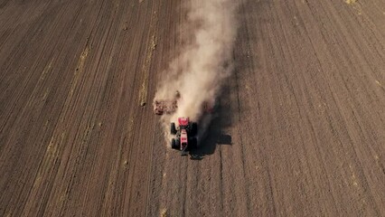 Wall Mural - Tractor disk harrow on plowing field. Cultivated land, soil tillage. Tractor disc cultivator on land cultivating. Agricultural tractor on cultivation field. Plough plowed farm field. Wheat planting