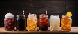 Fototapeta Paryż - Different beverages in glass jars on a table