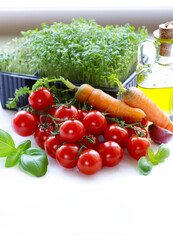 Wall Mural - Cherry tomatoes and fresh lettuce and basil on a white background