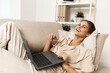 © SHOTPRIME STUDIO - Smiling woman working on laptop at home: A modern domestic freelance job