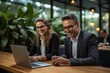 © Divine123victory - Happy business man and woman team working on laptop computer at the office desk. Smiling colleagues or entrepreneurs discussing a project. Concept with people using technology for work.
