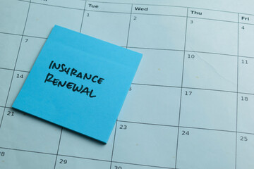 Wall Mural - Concept of Insurance Renewal write on sticky notes isolated on Wooden Table.