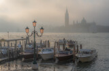 Fototapeta Sawanna - Gondolas in Venice at sunrise in morning fog. Veneto, Italy..