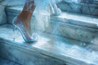 Close up of woman's feet in glass high heel shoes walking up stairs