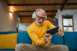 © Miljan Živković - senior old man sit at home play video games on smartphone mobile phone