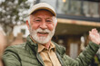 © Miljan Živković - One senior man stand outdoor in front of his house happy confident