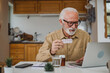 © Miljan Živković - One man senior caucasian male hold medicine drugs tablet read label