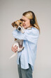 Dog and woman love hugging. expression of love and care by touching head to the pet. Dog is looking to the camera. Cute music lovers family studio shot grey and blue colors