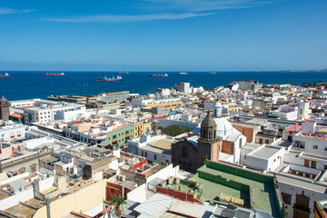 Freighter in the sea with roofs of a city  in the foreground