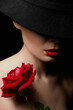 Beautiful young Woman In Hat and Flower. Pretty girl with make-up and Red Rose