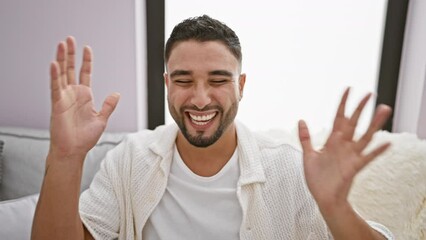 Sticker - Excited young arab man goes mad with joy on sofa at home, crazy gestures of triumph as he celebrates his massive win, arms raised in victorious success! indoor victory vibes!