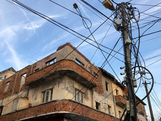 Wall Mural - old abandoned building with a jumble of illegal power hook ups to the power line