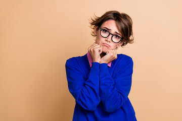 Sticker - Photo portrait of attractive young woman unhappy frowning pose fists cheeks wear trendy blue clothes isolated on beige color background