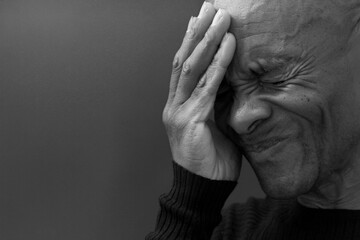 man praying to god with hands together Caribbean man praying with grey black background stock photo	