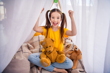 Poster - Photo portrait of charming small girl sit floor tent raise fists celebrate victory wear trendy yellow outfit children kindergarten playroom