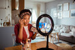 © Davor - Woman creating a makeup tutorial for her vlog at home