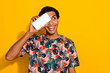 Photo of young guy hiding eye looking empty space with smartphone choose terms for credit deposit isolated on yellow color background