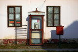 Fototapeta Storczyk - Stara budka telefoniczna i skrzynka pocztowa przy budynku poczty na Węgrzech