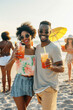 © zphoto83 - Trendy afro american couple in summer clothing having fun and drinking cocktails at beach party. Life style concept with young people having fun at sunset.