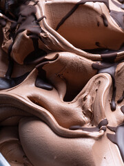 Wall Mural - Frozen Chocolate flavour gelato - full frame detail. Close up of a brown surface texture of chocolate Ice cream covered with dark chocolate topping.