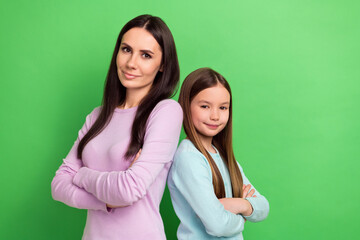 Wall Mural - Photo of two people mother daughter folded arms posing empty space isolated on bright green color background