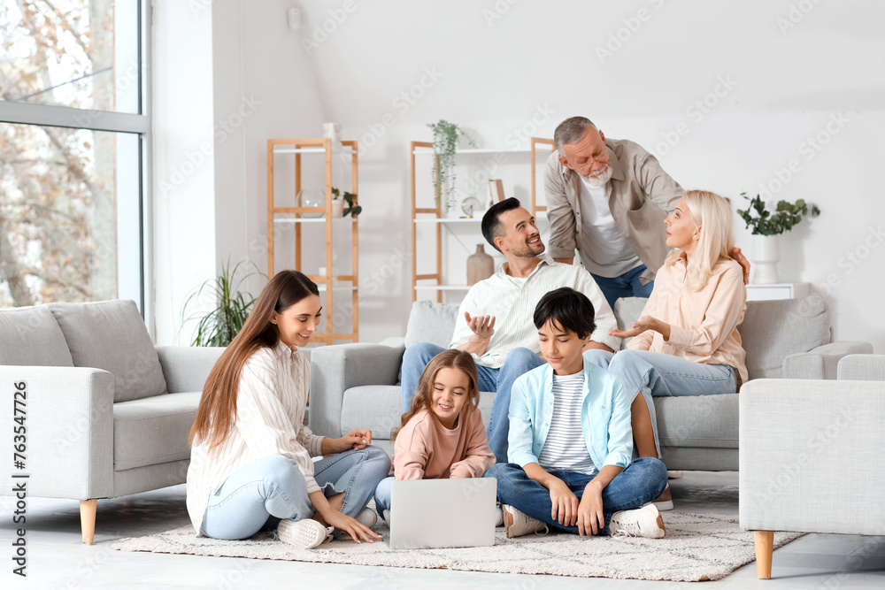 Big family with laptop spending time together at home