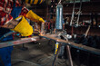 © Zamrznuti tonovi - Focus on man's hands in safety gloves assembling metal construction.