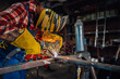 © Zamrznuti tonovi - Skilled worker in a protective gear welding metal with concentration.