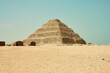 The pyramid of Djoser is built of hewn stone. Historic place on a background of blue sky in Egypt.