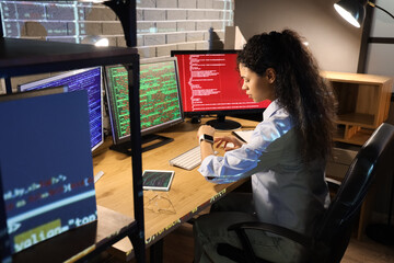 Female African-American programmer looking at smartwatch in office