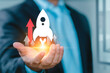 © Montri - Rocket being fast head up. Startup business concept, Businessman holding rocket icon and up arrow for fast start up business. Strategic planning and business success.
