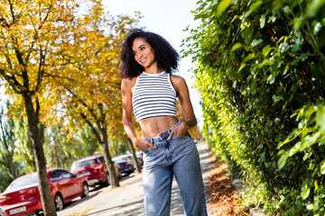 Poster - Photo of adorable cheerful girl curly hair traveling in city exploring new places sunny warm weather outside