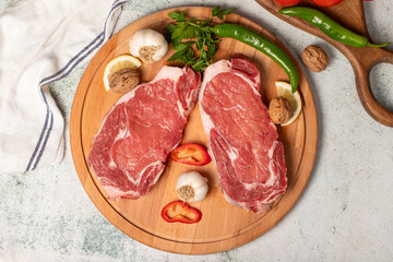 Canvas Print - Beef entrecote. Raw beef ribeye on wood serving board. Top view