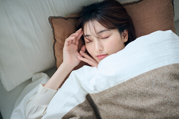 ベッドで眠る20代女性