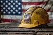Worn yellow safety helmet with American flag
