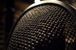 A detailed view of a microphone windscreen, with the texture of the foam visible, set in a dimly lit studio.