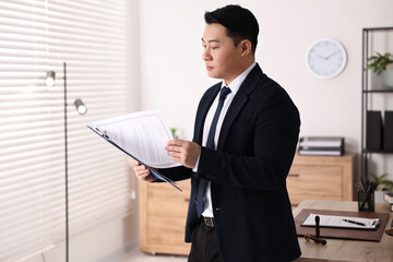 Canvas Print - Portrait of confident notary with clipboard in office