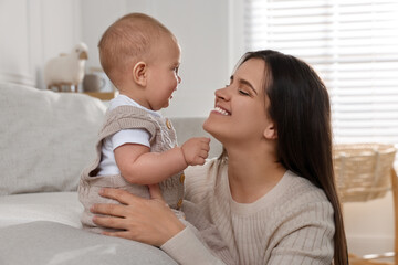 Wall Mural - Happy young mother with her baby in living room