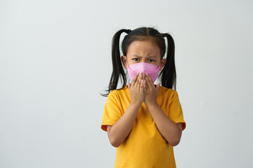 Little Asian girl wears a mask to help her breathe and protect her from dust, smoke, PM2.5, virus outbreaks, germs, and disease prevention concepts for the lungs, respiratory tract, and brain..