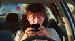 Reckless young man dangerously using smartphone while driving car