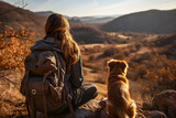 Fototapeta Londyn - mountain view background and back side of tourist woman. she's traveling with dog. they are best friend. she's holding a dog at view point at mountain. morning light and bokeh