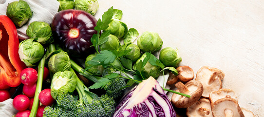 Canvas Print - Table with vegetables on a light wood background. Pepper, cabbage, broccoli, radish, garlic. Healthy eating concept