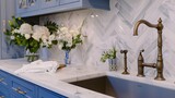 Fototapeta  - A scullery or butler's pantry detail with a bronze faucet and hardware, blue and white cabinets, and marble herringbone tile backsplash and countertop