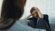 Sad PTSD woman patient in therapy for mental health with psychologist, depression or grief after life failure. Frustrated trauma young woman talking to prim psychologist about emotion in clinic