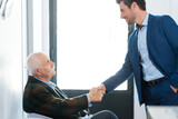 Fototapeta Panele - businessman greeting senior client in waiting room
