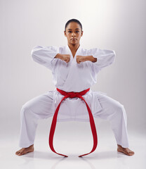 Wall Mural - Woman, portrait and karate fighter in studio, fitness and martial arts on white background. Black person, athlete and red belt for taekwondo, discipline and warrior ready for self defense or battle