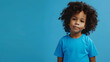 mockup featuring a young black boy wearing a blue t-shirt, set against a stylish blue background, exuding a sense of youthful energy and contemporary style