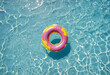 Inflatable pink and yellow donut ring floating on a blue background colorful background